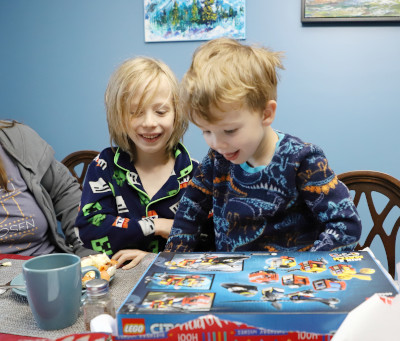 Andrew watches Alex open a present.